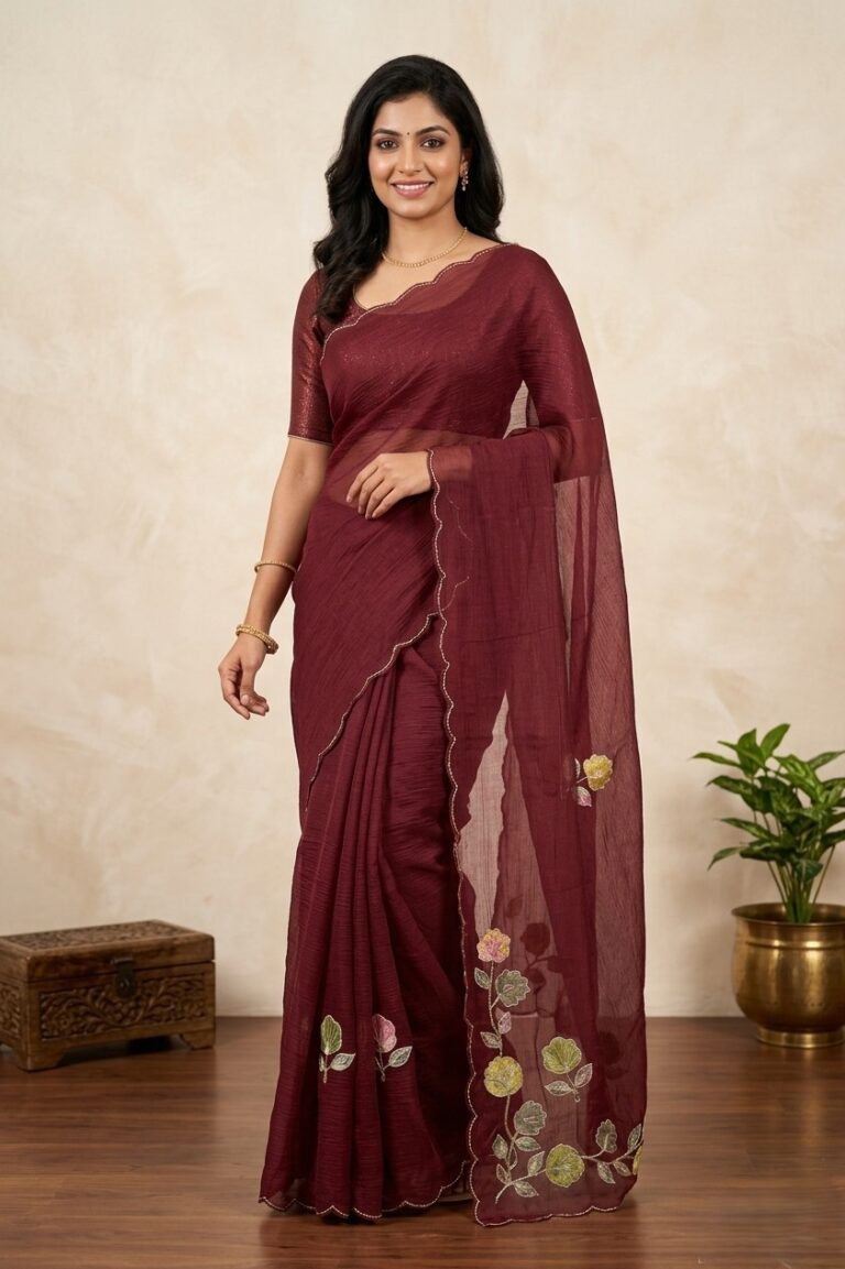 Deep maroon crush chiffon party wear saree draped on a mannequin, highlighting scalloped borders and floral embroidery motifs.