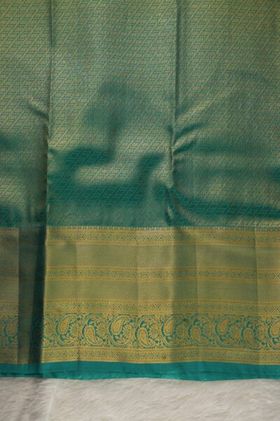 A detailed full view of the rich, dense gold zari geometric diamond brocade pallu woven on the sea green base of the semi pattu silk saree.