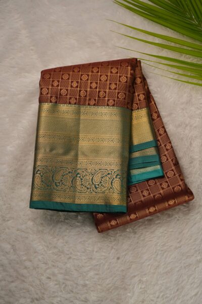 Elegantly folded outlook of the maroon semi pattu art silk saree, displaying the stunning contrast between the zari checked body and the rich sea green border.