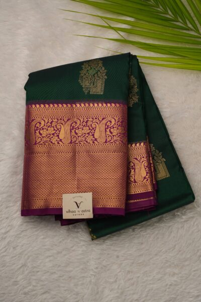 Elegantly folded outlook of the bottle green semi pattu art silk saree, displaying the stunning contrast between the deep green body and the vibrant magenta border.