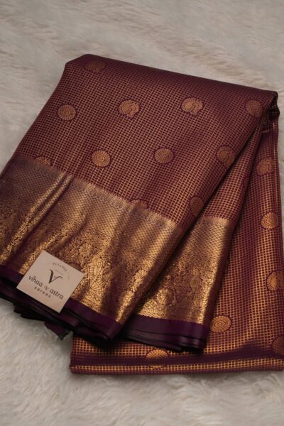 Elegantly folded outlook of the dark wine semi pattu art silk saree, displaying the stunning overall texture of the zari checks and the rich self border.