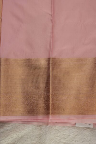 Plain baby pink unstitched blouse piece featuring the intricate gold zari Kanchi border, perfectly complementing the heavy brocade semi pattu saree.