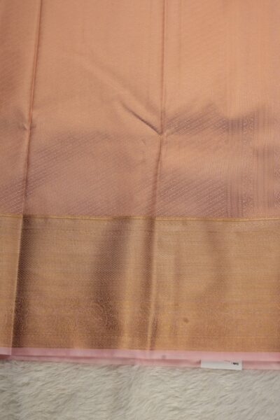 A detailed full view of the rich, dense gold zari geometric diamond brocade pallu woven on the baby pink base of the semi pattu silk saree.
