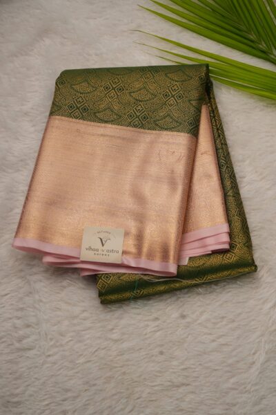 Elegantly folded outlook of the green semi pattu art silk saree, displaying the stunning contrast between the intricate all-over zari brocade body and the rich baby pink border.