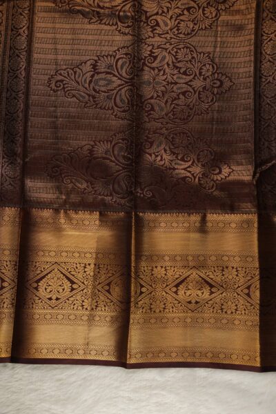 A detailed full view of the rich, dense gold zari geometric diamond brocade pallu woven on the coffee brown base of the semi pattu silk saree.