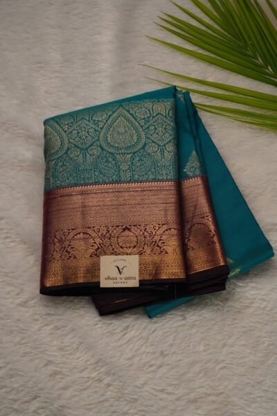 Elegantly folded outlook of the green premium semi pattu art silk saree, displaying the stunning contrast between the intricately woven green body and the rich magenta border.