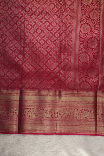 A detailed full view of the rich, dense gold zari geometric diamond brocade pallu woven on the vibrant pink base of the semi pattu silk saree.
