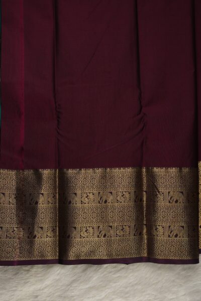 Plain burgundy unstitched blouse piece featuring the intricate gold zari elephant and peacock border, perfectly matching the green semi pattu saree.