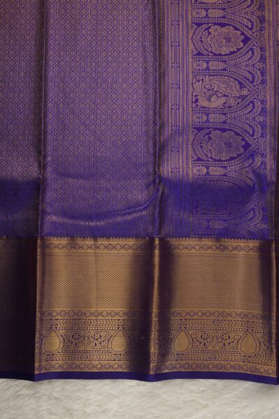 A detailed full view of the rich, dense gold zari geometric diamond brocade pallu woven on the deep purple base of the semi Kanjeevaram silk saree.