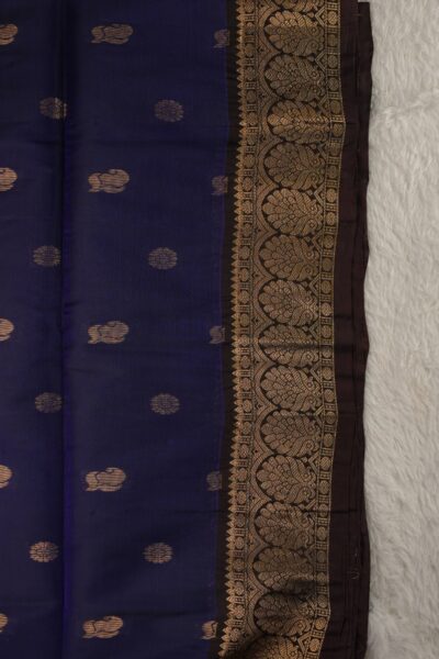 Close-up texture of a navy blue lightweight Pattu saree with alternating floral and paisley metallic buttis, alongside a beautifully detailed coffee brown gold zari border.