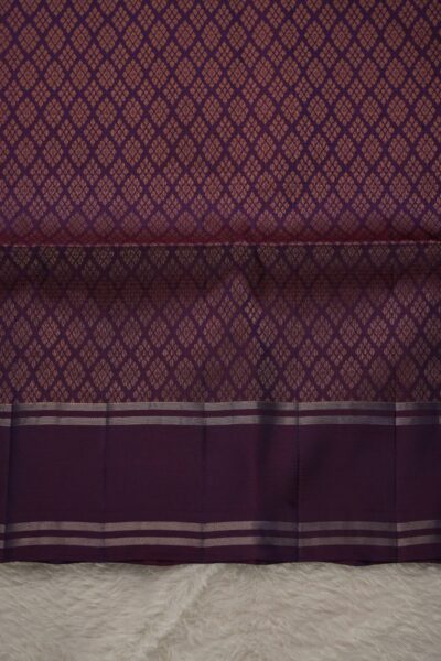 Heavy brocade deep magenta pallu of a lightweight Pattu saree, featuring a dense all-over geometric diamond zari pattern.