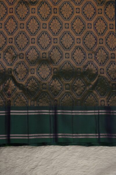Heavy brocade bottle green pallu of a lightweight Pattu saree, featuring a dense all-over geometric diamond and floral metallic pattern.
