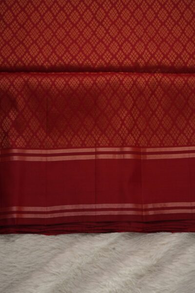 Heavy brocade deep red pallu of a lightweight Pattu saree, featuring a dense all-over geometric diamond zari pattern.