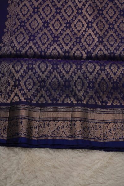 Heavy brocade deep blue pallu of a lightweight Pattu saree, featuring a dense all-over gold zari geometric diamond pattern.