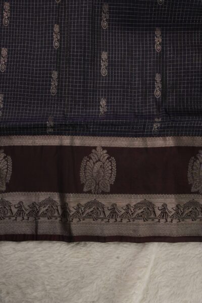 Close-up texture of a navy blue lightweight Kanchi Pattu saree showing woven checks and vine buttis, alongside a deep coffee brown gap border displaying a grand central motif and a delicate palanquin procession scene.