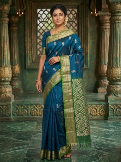 Elegant deep blue lightweight Pattu saree with floral zari buttis and a contrast green geometric zari pallu with tassels.