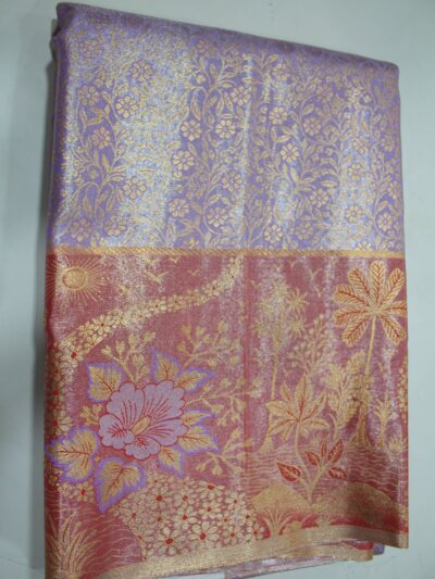 Folded lavender Semi Kanchi Pattu saree showing an all-over gold zari botanical brocade and a heavy contrasting rose-red border featuring a woven landscape with palm trees, a sun, and a large floral motif accented with purple Meenakari weaving.
