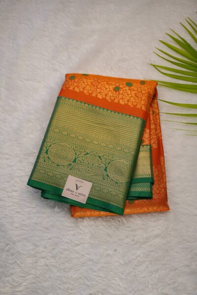 Elegantly folded outlook of the orange semi pattu art silk saree, displaying the stunning contrast between the vibrant orange body and the rich green border.