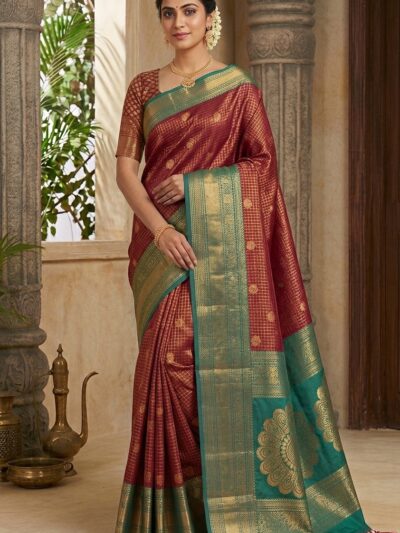 Beautiful woman wearing a deep red premium semi Kanchi Pattu saree featuring gold zari checks and a contrasting green heavy zari pallu with large floral mandala motifs.