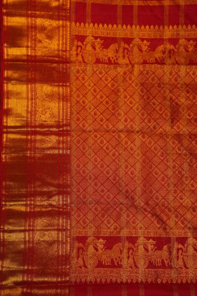 The grand, heavy gold zari brocade pallu of the red pure handloom Kanjeevaram saree showcasing dense diamond patterns and traditional chariot narrative motifs.