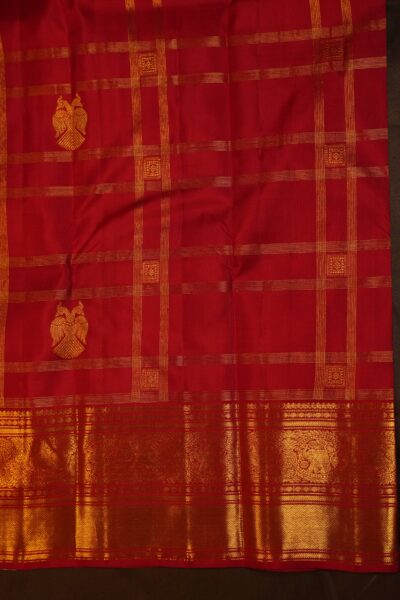 Close-up texture of the red handloom Kanjeevaram silk featuring the intricate twin-headed bird (Iruthalai Pakshi) zari motif nestled within vintage Kanchi checks.