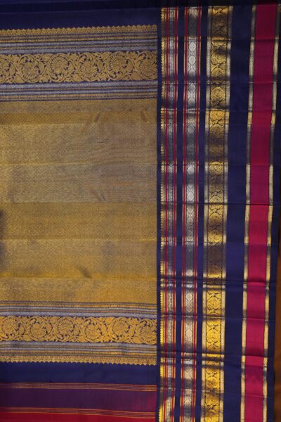 A detailed full view of the rich, dense gold zari geometric diamond brocade pallu woven on the deep vintage blue base of the handloom saree.