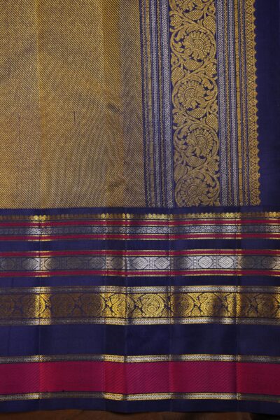 Close-up highlighting the intricate transition between the geometric diamond brocade pallu and the traditional peacock motifs on the blue border.