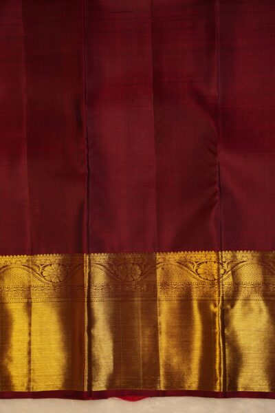 Plain maroon unstitched blouse piece featuring the intricate gold zari Kanchi border, perfectly matching the rose pink handloom saree.
