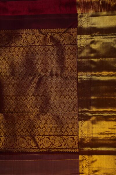A detailed full view of the rich, dense gold zari geometric diamond brocade pallu woven on the deep maroon base of the handloom Kanjeevaram saree.