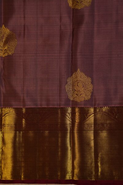 Close-up texture of the pure handloom rose pink silk body showing woven gold buttis alongside the heavy, intricate gold zari work of the maroon Kanchi border.