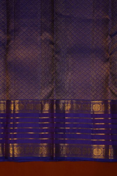 A detailed view of the rich, dense gold zari geometric brocade pallu woven on the deep blue base of the pure handloom Kanjeevaram saree.