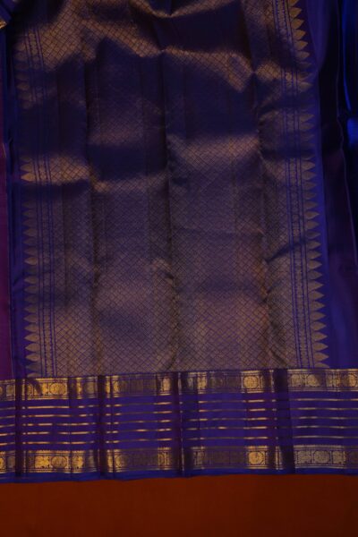 Close-up shot highlighting the intricate geometric diamond patterns and traditional peacock motifs on the grand zari pallu of the Kanjeevaram pattu saree.