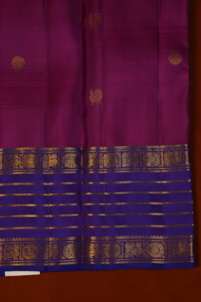 Close-up texture of the pink Kanjeevaram silk body alongside the contrast border, highlighting its deep blue and vintage purple tones.