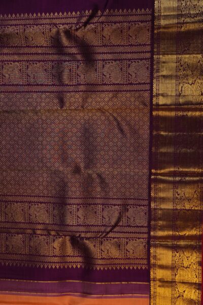 A detailed full view of the rich, dense gold zari geometric diamond brocade pallu woven on the deep magenta base of the handloom saree.