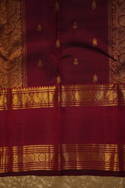A detailed full view of the rich, dense gold zari geometric diamond brocade pallu woven on the deep maroon base of the handloom Kanjeevaram saree.