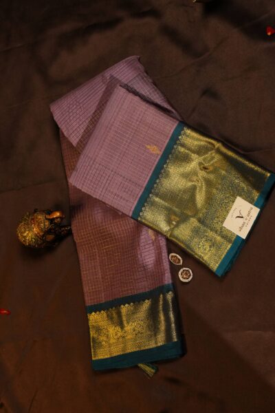 Elegantly draped outlook of the pure handloom striped Kanjeevaram pattu saree, displaying the stunning contrast between the warm peach body and the deep navy blue border.