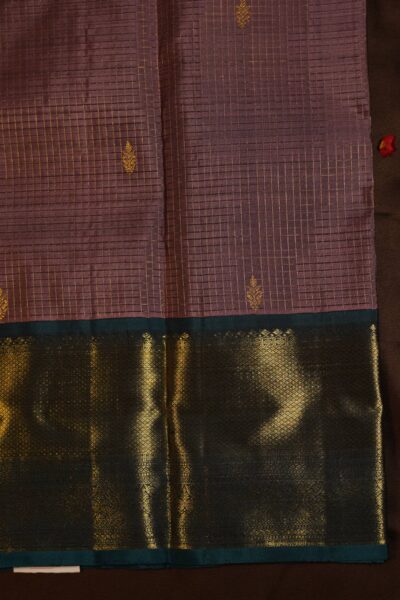 Close-up texture of the pure handloom peach silk body showing woven vintage gold zari lines alongside the heavy, intricate gold zari work of the navy blue Kanchi border.