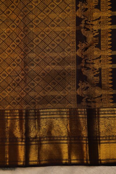 Close-up highlighting the intricate transition between the geometric diamond brocade pallu and the traditional peacock motifs on the heavy brown border.