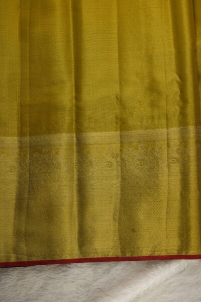 Plain golden yellow tissue unstitched blouse piece with an intricate zari border and red selvedge matching the Kanjeevaram Pattu saree.