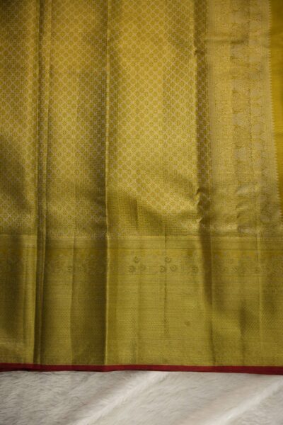 Heavy brocade pallu of a golden yellow pure tissue Kanjeevaram Pattu saree, featuring a dense geometric and floral zari pattern.