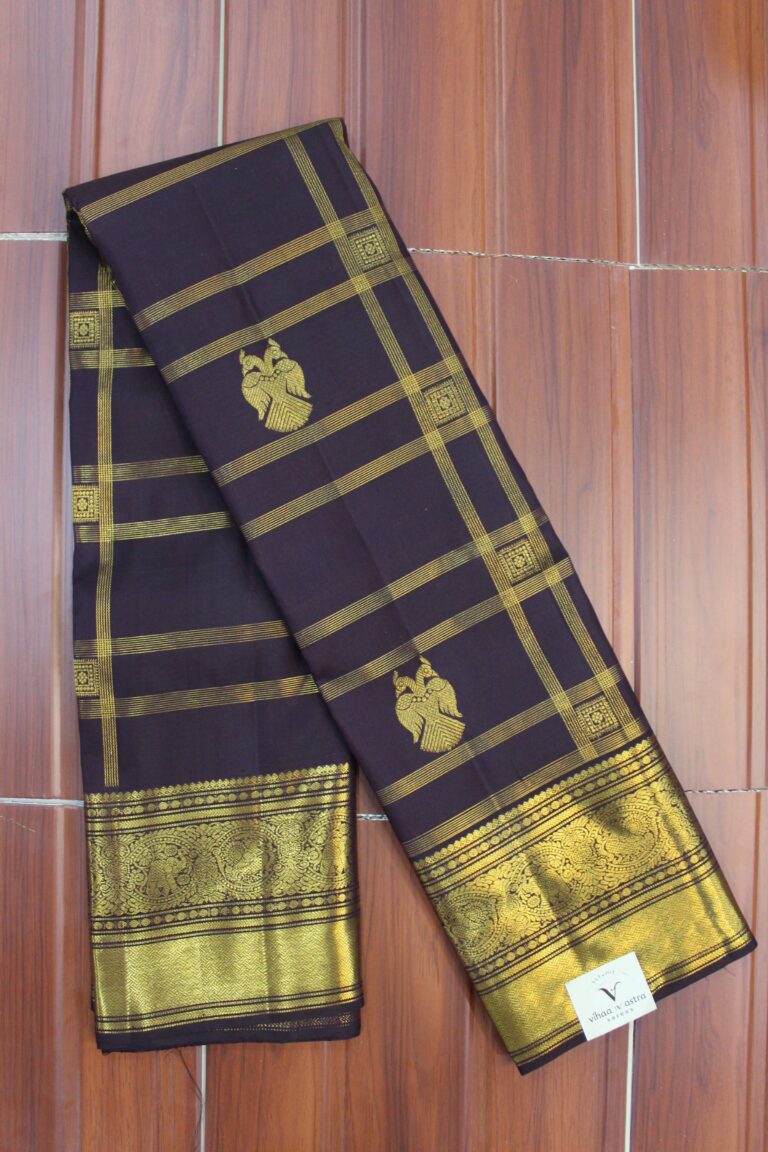 Folded deep plum pure handloom Kanjeevaram silk saree featuring gold zari checks with twin-bird motifs, showcasing a heavy gold zari border and pallu intricately woven with elephants and peacocks.