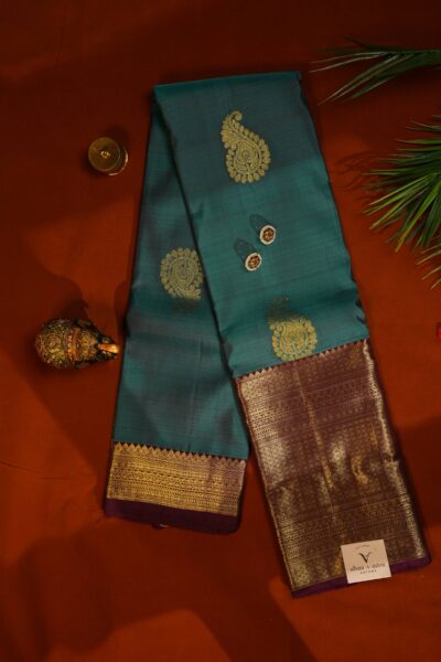 Elegantly draped outlook of the pure handloom Kanjeevaram pattu saree, displaying the stunning contrast between the tea green silk and the deep maroon border.