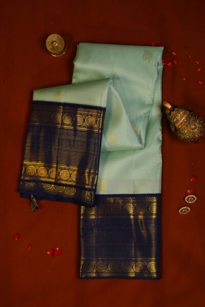 Elegantly draped outlook of the pure handloom striped Kanjeevaram pattu saree, displaying the stunning contrast between the pista green body and the deep navy blue border.