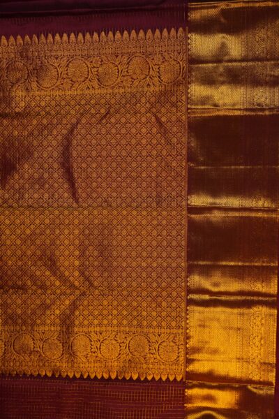A detailed full view of the rich, dense gold zari geometric diamond brocade pallu woven on the deep maroon base of the handloom Kanjeevaram saree.