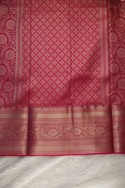 A detailed full view of the rich, dense gold zari geometric diamond brocade pallu woven on the vibrant pink base of the semi pattu silk saree.