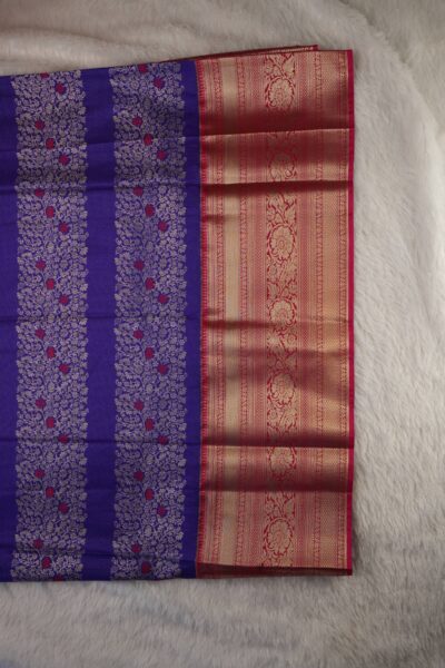 Close-up texture of the purple blended silk body showing vertical gold zari lines alongside the heavy, intricate gold zari peacock work of the pink Kanchi border.