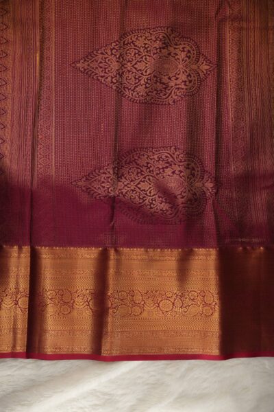 A detailed full view of the rich, dense gold zari geometric diamond brocade pallu woven on the vibrant pink base of the semi Kanjeevaram silk saree.
