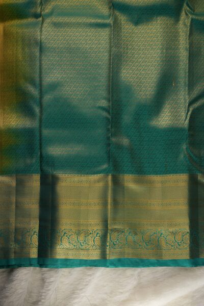 A detailed full view of the rich, dense gold zari geometric diamond brocade pallu woven on the sea green base of the semi pattu silk saree.