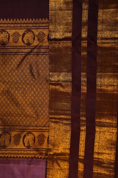 The magnificent, dense gold zari brocade pallu of the light burgundy handloom Kanjeevaram saree, showcasing traditional peacock roundels and diamond patterns on a maroon base.