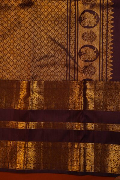 A detailed half-view showing the transition between the dense gold zari brocade pallu and the rich multi-band gap border of the pure handloom Kanjeevaram saree.